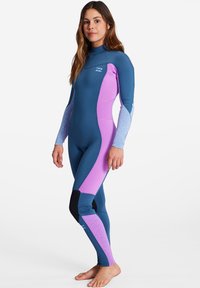 Wetsuit featuring a mix of dark blue and light purple panels, long sleeves, high collar, and textured accents on the arms and legs.