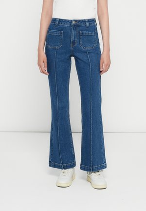 Blå utsvingte jeans laget av denim, med høy midje, to baklommer og hvite sømmer langs sømmene.