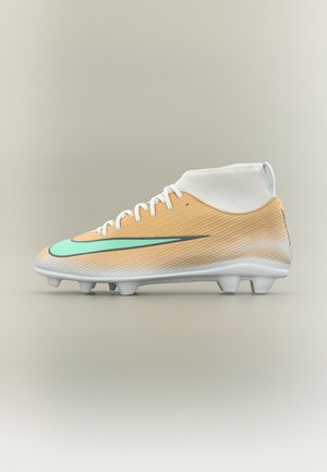 Chaussure de football montante beige et blanche avec lacets blancs, logo Nike bleu clair et crampons blancs sur fond neutre.