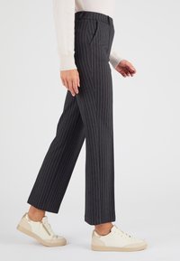 Grijze pinstriped broek met een rechte snit, voorzien van zijzakken en een gladde textuur, gecombineerd met crèmekleurige sneakers.