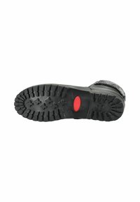 Semelle de botte noire avec une surface rugueuse et texturée, présentant des motifs de semelle pour une meilleure adhérence et un accent rouge au centre.