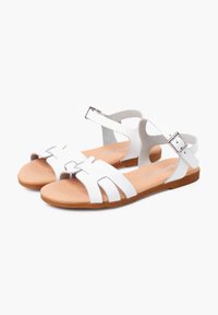 Sandali bianchi con più cinturini ritagliati, cinturino alla caviglia regolabile con fibbia metallica e suola in materiale marrone texturizzato. Design piatto per il massimo comfort.