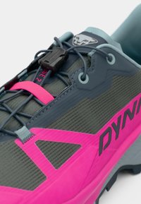 Παπούτσι ορεινής τρεξίματος σε γκρι χρώμα με φωτεινές ροζ λεπτομέρειες. Διαθέτει υφασμάτινη επιφάνεια με υφή, ασφαλές σύστημα δέσμευσης και έντονη σόλα για καλύτερη πρόσφυση.