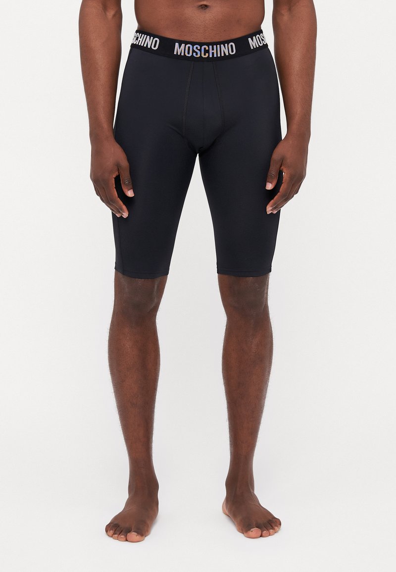 Shorts en stretch noirs Moschino avec une taille élastique à logo, design ajusté, coupe au genou et texture lisse.