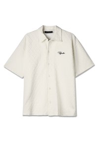 Wit overhemd met korte mouwen, met een doorgestikte textuur en ruitpatroon, en een zwart geborduurd "Pegador" logo op de linkerborst. Vijf knopen aan de voorkant.