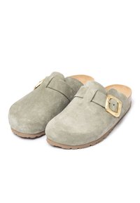 Wildlederschuhe in sanftem Grün mit einer hellbraunen Gummisohle. Sie verfügen über eine goldfarbene Schnalle und ein minimalistisches Design. Die weiche Textur sorgt für Komfort.