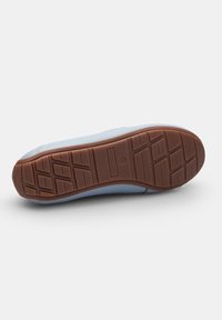 Niebieski sneaker z gładką cholewką, wyposażony w brązową gumową podeszwę z teksturowanym wzorem bieżnika dla lepszej przyczepności. Czysty design, minimalna ilość detali.