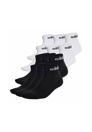 Quattro paia di calze alla caviglia in bianco e nero, con polsino a costine e logo "adidas" ricamato sulla parte superiore. Materiale misto cotone.
