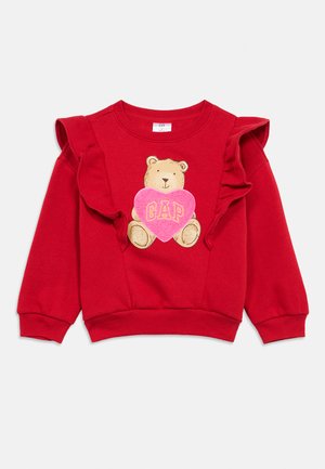 Rotes Sweatshirt mit gerafften Ärmeln, mit einer Bärengrafik, die ein pinkes Herz mit dem Schriftzug "GAP" hält. Weicher Stoff, legerer Schnitt.