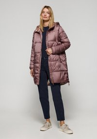 Cappotto gonfiato di media lunghezza in morbido mauve con una finitura lucida, dotato di cappuccio, tasche con zip e dettaglio logo lungo la spalla.