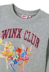 Felpa grigia con la scritta "WINX CLUB" in paillettes rosa. Il design frontale mostra tre personaggi fatati con abiti colorati e ali.