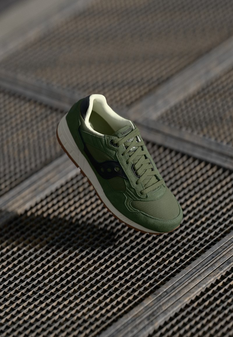 Roheline spordijalgpall, mis on valmistatud nahast ja võrkmaterjalist, tekstuuriga pind, valge vaheline tall ja pruun kummist väljatall.