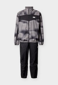 Αθλητικό σετ δύο τεμαχίων σε μαύρο και γκρι με ριγέ μπουφάν, φερμουάρ μπροστά, ελαστικές μανσέτες και μαύρο παντελόνι με ελαστικούς αστραγάλους.
