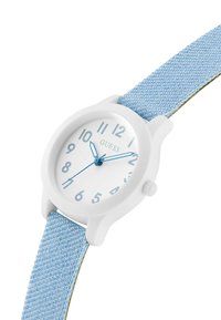 Reloj analógico blanco con correa de tela en azul claro. Caja redonda, esfera clara marcada con números árabes, manecillas azules y correa texturizada.