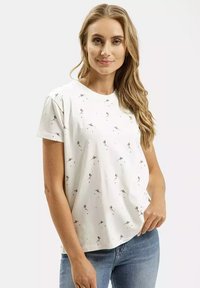 Biała koszulka z krótkim rękawem z kwiatowym wzorem w stonowanych kolorach. Miękka bawełniana tkanina, luźny krój, okrągły dekolt, gładka faktura.