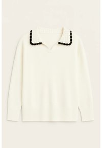 Hvid trøje med V-udskæring, kontrasterende tekstureret krave i sort og hvid, ribstrikkede manchetter og kant, blødt materiale, afslappet pasform.