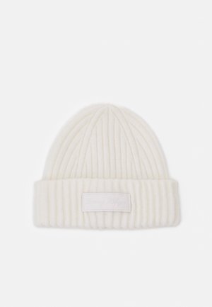 Bonnet en tricot côtelé blanc avec revers plié et patch rectangulaire cousu au centre avant.
