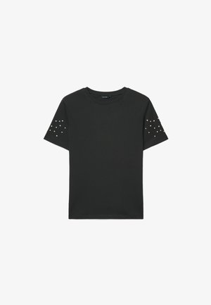 T-shirt nero a maniche corte con scollo rotondo, decorata con piccoli borchiette argentate sparse su entrambe le maniche.