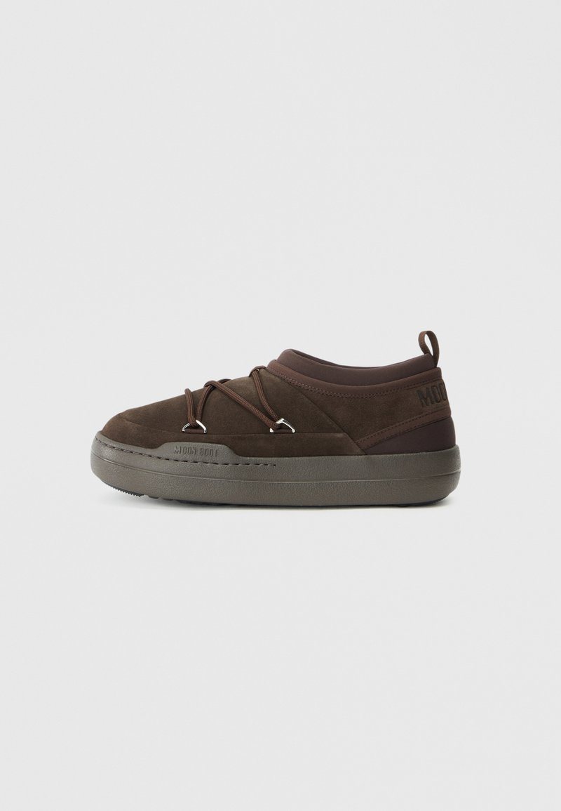 Zapatillas de ante marrón con punta redondeada, cordones elásticos y una suela texturada gris. Presenta una marca en el talón.