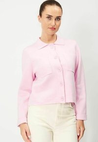 Ljust rosa kort jacka med krage, knäppning framtill och två framfickor, tillverkad av ett texturerat tyg.