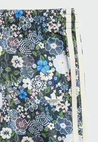 Kvetinové plavky s námořníckym pozadím, farebnými vzormi kvetov, svetlými bočnými prúžkami a malým vyšitým logom.