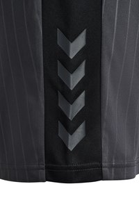 Svarta sportshorts med ett texturerat tyg med vertikala ränder och tydliga grå chevron-accenter på sidan.