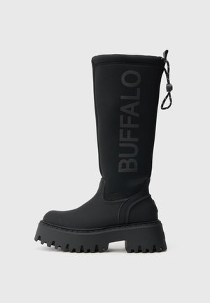 Black rubber knee-high boot with a chunky sole, featuring a textured surface and embossed "BUFFALO" logo on the outer side. Adjustable top.