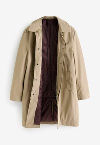 Beige vettē coat, joka on vedenkestävä ja jossa on kaulus, vetoketju ja nappisulku, kaksi etutaskua sekä kontrastiväri tumman violetin vuorin.