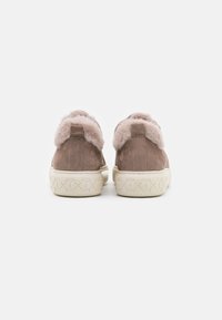Zapatillas de ante marrón con un cuello de felpa rosa, suela de goma blanca texturizada y detalles de costura en la parte posterior.