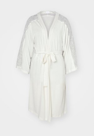 Robe bianco con dettagli in pizzo sulle maniche, dotata di una cintura da annodare e maniche a tre quarti. Tessuto morbido e fluido con una vestibilità comoda.