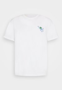 Valkoinen lyhythihainen T-paita, jossa on pieni brodeerattu maapallohahmo skeittaamassa vasemmassa ylärinnassa.