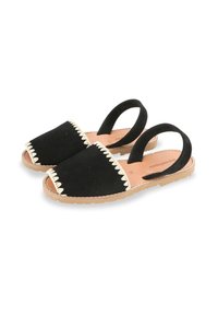 Sandales en suède noir avec deux sangles arrière, bord beige festonné et semelle couleur naturelle. Design plat avec orteils et talons ouverts.