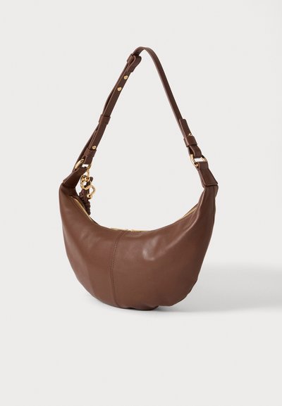 Sac à main demi-lune en cuir marron avec bandoulière réglable et ferrures dorées, y compris une fermeture éclair et des attaches, présenté sur un fond uni.