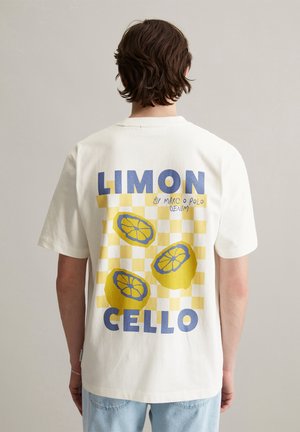 White cotton t-shirt featuring a yellow and blue graphic design with lemon illustrations and a checkered background. "LIMON CELLO" text included.