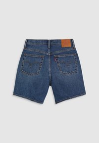 Mörkblå denimshorts med sydda bakfickor, en läderetikett och en rak fåll. Har en klassisk femficksdesign.
