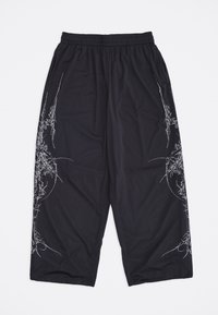 Μαύρο παντελόνι φαρδιάς γραμμής από δίχτυ με ελαστική μέση και λευκά αφηρημένα σχέδια γραμμών στα πλάγια, σε λευκό φόντο.