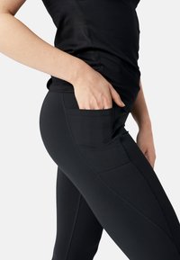 Leggings athletic neri con tasca laterale, texture liscia e design delle cuciture curve per un adattamento e un comfort ottimali.