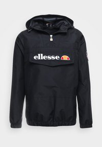 Sort vindjakke med hætte, udstyret med et stort hvidt "ellesse" logo foran, elastiske manchetter og snoretræk i kanten.
