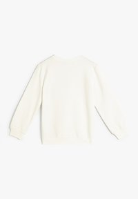 Krämfärgad sweatshirt med långa ärmar, ribbade manschetter och rund halsringning. Slät tyg utan synliga sömmar eller dekorationer.