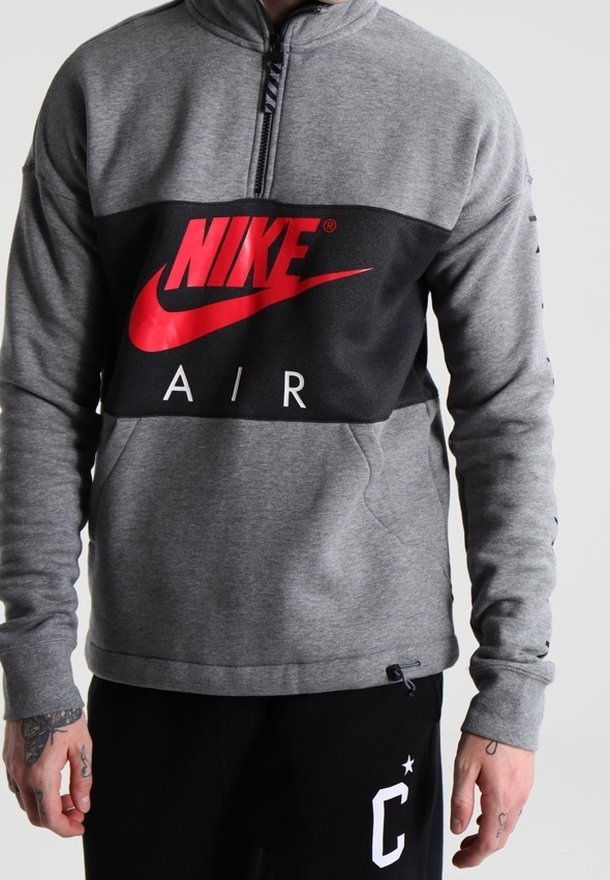 Šedá mikina Nike s černým panelem a červeným logem. Design s čtvrtinovým zipem, dlouhými rukávy a texturovaným povrchem.