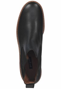 Botín negro de cuero con acabado texturizado, paneles laterales elásticos y suela marrón cosida. El interior presenta un forro suave.