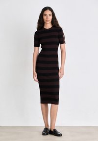 Abito a maglie con maniche corte, caratterizzato da righe orizzontali nere e marrone scuro. Include dettagli intrecciati sulle maniche e una silhouette aderente.