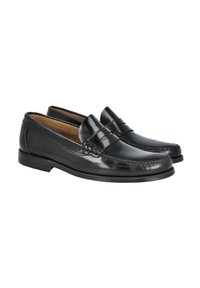 Mocasines de cuero negro con un acabado suave y costuras decorativas. Cuentan con una punta redondeada y una suela baja de cuero.