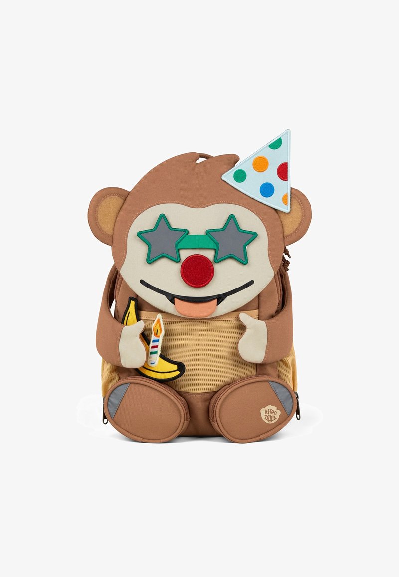Brown fabric backpack shaped like a monkey with a party hat, star-shaped glasses, and a banana. Features appliqué details, textured areas, and zippers.
