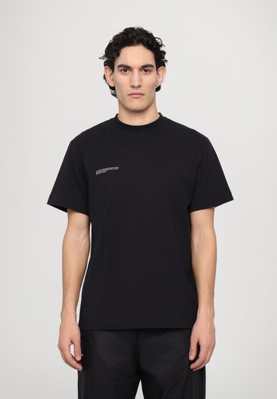 Tricou negru din bumbac cu guler rotund, mâneci scurte și un mic detaliu de text alb în față. Textură netedă și croială relaxată.