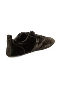 Zapatillas de terciopelo negro con un perfil bajo, puntera redondeada, cordones en la parte frontal y detalles de costura sutiles. Textura suave y diseño minimalista.