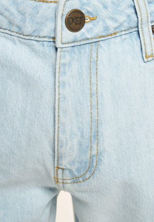 Jasnoniebieskie dżinsy z metalowym guzikiem, kontrastowymi żółtymi przeszyciami oraz klasycznym pięciopocketowym designem, z wyblakłą fakturą.
