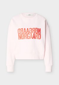Sweat-shirt rose clair à manches longues avec un texte rouge audacieux "NØRGAARD" imprimé deux fois, l’un inversé au-dessus de l’autre, sur le devant.