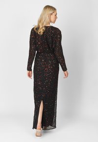 Zwart paillettenjurk met lange mouwen, een achterkant met split en meerkleurige versieringen, ontworpen voor een getailleerde silhouette.