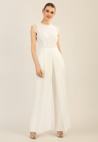 Weißer Jumpsuit mit spitzenbesetztem Oberteil und kurzen Ärmeln, tailliertem Schnitt und weit geschnittenen Hosenbeinen. Glattes Material mit subtiler Lichtreflexion.
